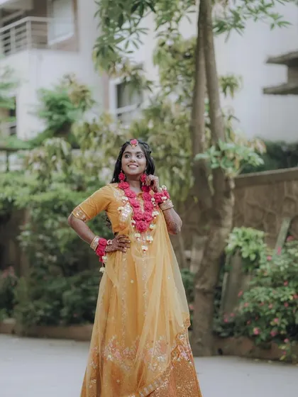 The bride posing outdoors during her Haldi ceremony.