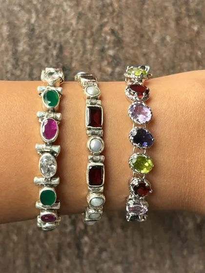 A glimpse of our popular silver stone bracelets stacked on the wrist. We offer a variety of designs featuring semi-precious stones like emerald, ruby, amethyst, and pearl, perfect for adding a pop of colour to any outfit.
