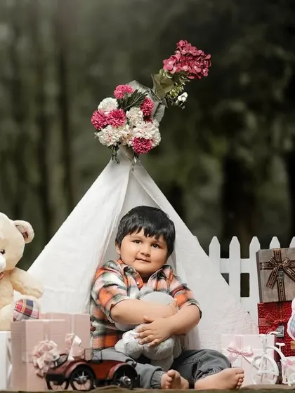 A cozy moment with a favorite stuffed animal. This three-year-old boy is enjoying a quiet moment in his teepee during his birthday photoshoot.