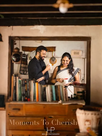 A warm and candid shot of a couple sharing a laugh over coffee in a cozy, book-filled nook of a traditional house. This 'Moment to Cherish' feels authentic and full of personality.