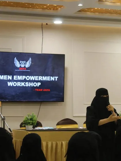 A speaker addresses the audience at our Women Empowerment Workshop. These sessions are designed to inspire and educate, providing both mental and physical tools for empowerment.