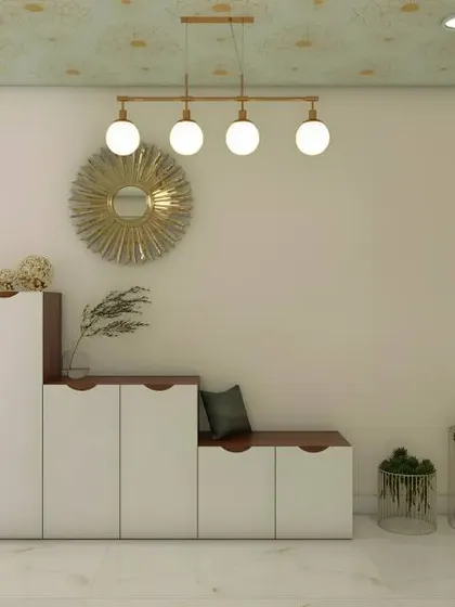 A modern shoe cabinet with a stepped design that incorporates a small seating area. The gold sunburst mirror and pendant light add a stylish touch.