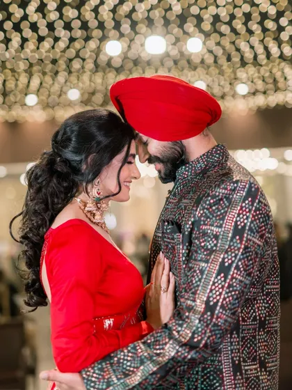 An intimate close-up under a ceiling of fairy lights. The soft bokeh and their gentle forehead touch create a dreamy, romantic atmosphere that feels magical.