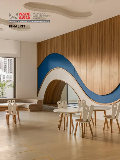 A classroom at Vedanya School featuring a playful, wave-like wall with a built-in tunnel. This imaginative design element turns the room into a landscape for discovery and creative play.
