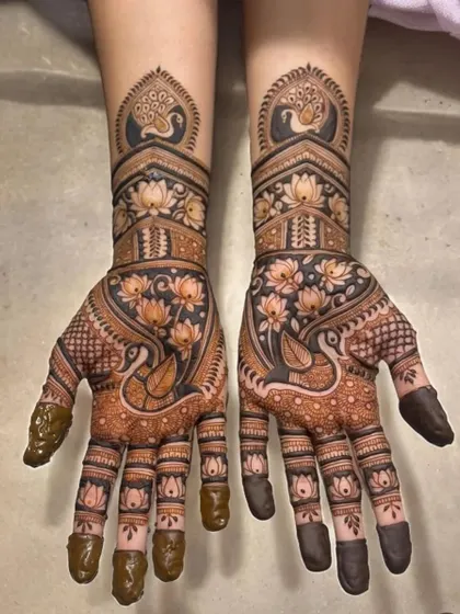 This design is a celebration of nature, with peacocks, swans, and lotus flowers covering the hands in a beautiful, flowing pattern.