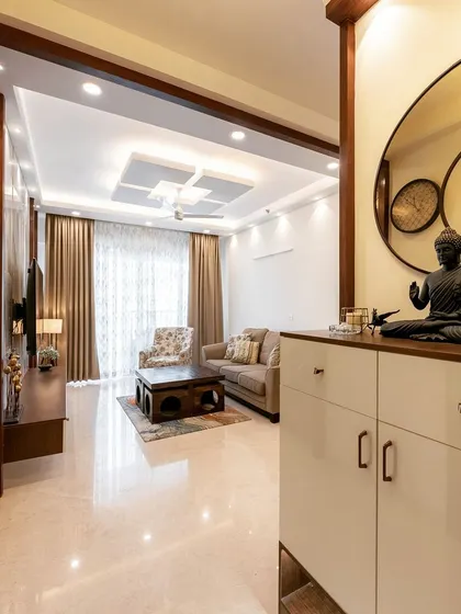 A view from the foyer into the living room, showing a well-placed shoe cabinet with a Buddha statue, creating a peaceful and welcoming first impression.