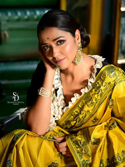 A beautiful close-up of Sohini Sarkar, her face framed by her hand. Her gentle expression and the rich colors of her outfit make for a captivating portrait.
