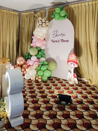 An angled view of the fairy birthday setup, showing the placement of the large marquee number '3' and the balloon garland.