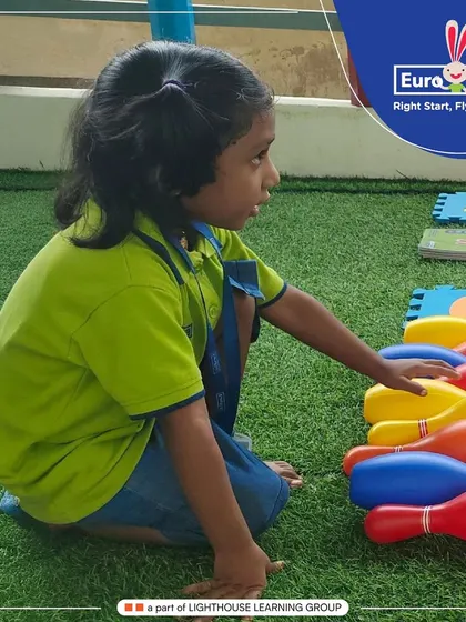 Learning numbers is fun with hands-on activities. Here, a child practices counting and number recognition by setting up colorful bowling pins, connecting the abstract concept of numbers to a physical game.