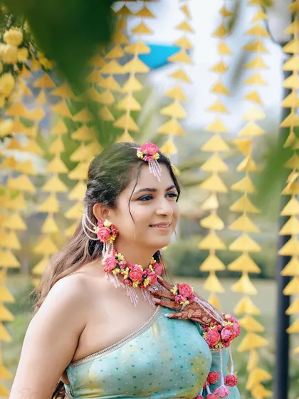 A close-up of the bride, showcasing her beautiful floral jewelry, a popular choice for Haldi and Mehendi events.