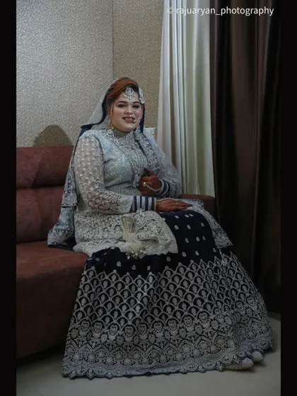 A slightly different angle of the seated bridal portrait, capturing her warm smile as she looks towards the camera.