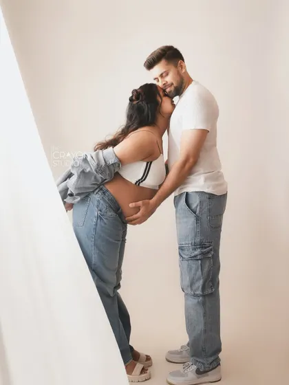 A sweet kiss on the cheek. This casual and loving gesture is a beautiful way to document the affection and bond during pregnancy.