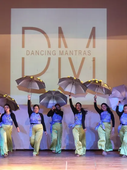 A glimpse from our 'City of Stars' showcase, where my students owned the stage. I love incorporating props like these umbrellas to add a unique visual flair to a group dance, creating a truly memorable sangeet performance.