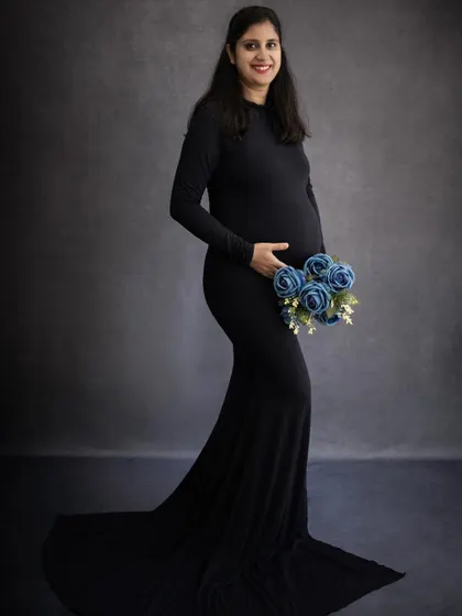 A simple, classic solo maternity portrait. The mom-to-be holds a bouquet of blue flowers, adding a soft pop of color to this elegant black-and-white look.