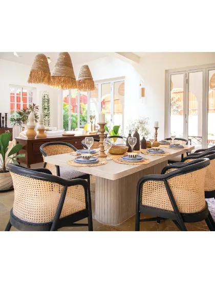 In this Goan holiday home, we used natural materials to create a dining space that feels connected to its context. The table features a leather-finish Shahbad stone top, paired with black and cane chairs that are both durable and stylish.