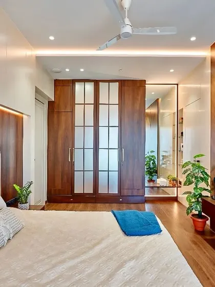 A closer look at the bedroom with chevron-patterned wood paneling. This angle shows the seamless integration of the frosted glass wardrobe doors, which add a touch of softness to the design.