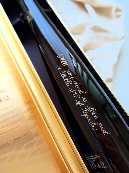 "All you need is love and a little bit of Tequila." A fun and stylish quote engraved on a Don Julio 1942 bottle, showcasing how personalization can add character and wit to a gift.
