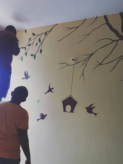 My team at work on a nature-themed wall mural. We take care to execute every detail of the design, transforming a plain wall into a piece of art.