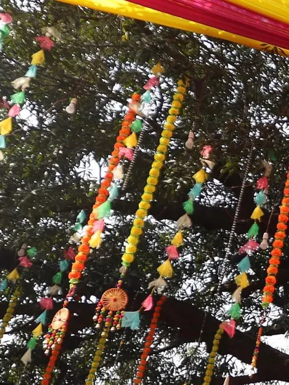 A close-up of the decorative hangings used in our Haldi setups. We love using colorful tassels and traditional genda phool strings to add texture and a traditional touch to the decor.