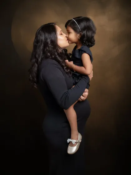 A kiss that says it all. This timeless black and white frame captures a mama with her first little love, while carrying her second one close to her heart.