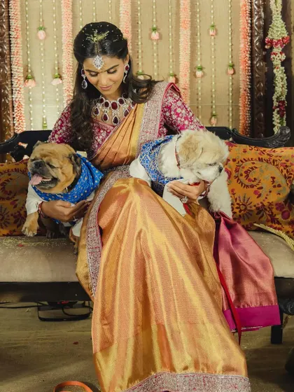 A heartwarming moment as Manisha poses with her adorable dogs, who are also dressed for the occasion. This shows that even pets can be part of the wedding style story.