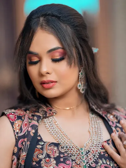This modern layered necklace with green stones is perfect for a contemporary bride. It's paired here with a printed lehenga for a chic look.