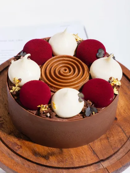 A modern take on the classic Black Forest cake, with delicate spheres of cherry mousse, white chocolate cream, and a rich chocolate base.