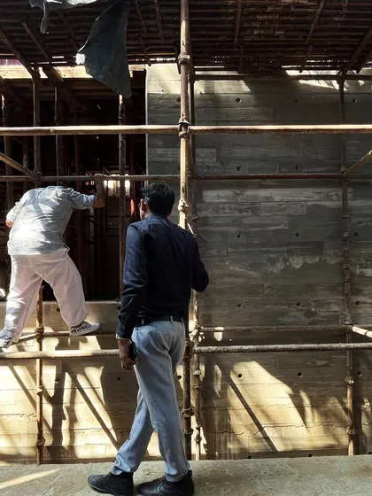 Workers navigating the scaffolding during the construction of the concrete walls. The process is labor-intensive and requires great precision.