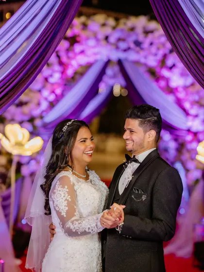 The first dance as husband and wife. Under the vibrant purple lights, Eliza's bridal glow is undeniable.