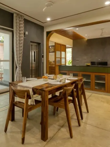 The dining space is connected to the outdoors through large sliding glass doors, flooding the area with natural light.