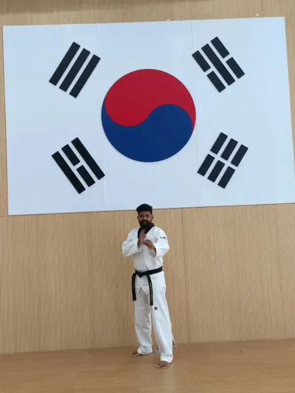 Standing before the Taegukgi, the flag of South Korea, the birthplace of Taekwondo. A symbol of the deep respect we have for the art's origins.