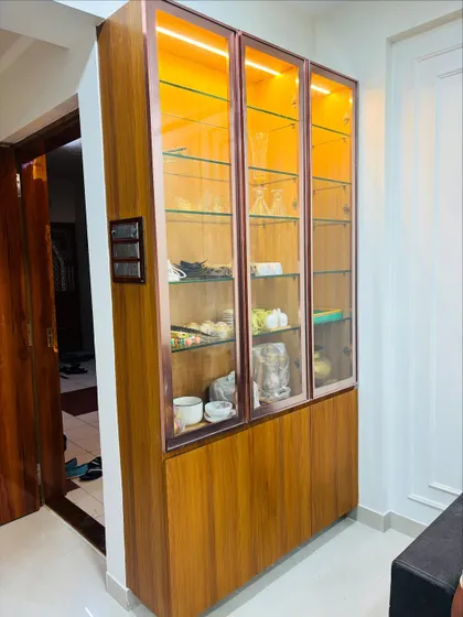 I also design other storage solutions, like this crockery unit. It combines a wooden base with glass-fronted upper cabinets featuring warm internal lighting to display your finest dinnerware.