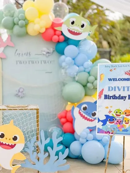 The complete Baby Shark party scene, including the welcome sign and a backdrop that makes you feel like you're under the sea.