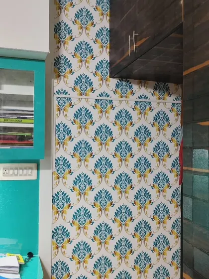 A bright blue and yellow damask-style wallpaper, adding a pop of color to a small space.