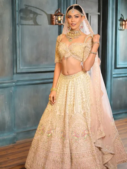 When less is truly more. This full-length shot showcases a breathtaking ivory lehenga, with glam makeup that enhances natural beauty for an effortlessly radiant bridal look.