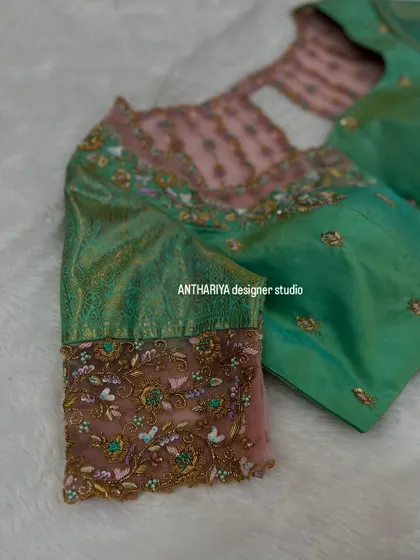 A close-up of the floral embroidery on the sheer net cuff of the sleeve.