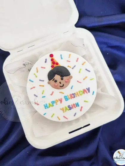 A cute and colorful bento cake for a child's birthday. The hand-drawn face and rainbow sprinkles make it a simple, joyful celebration cake.