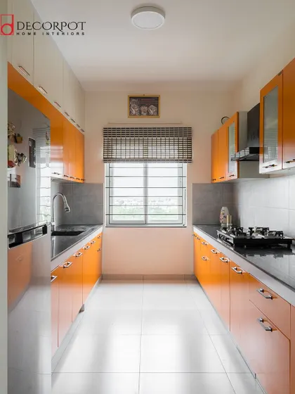 A bright and cheerful parallel kitchen with glossy orange cabinets. This design shows how a bold color can bring energy and personality to a functional galley layout.