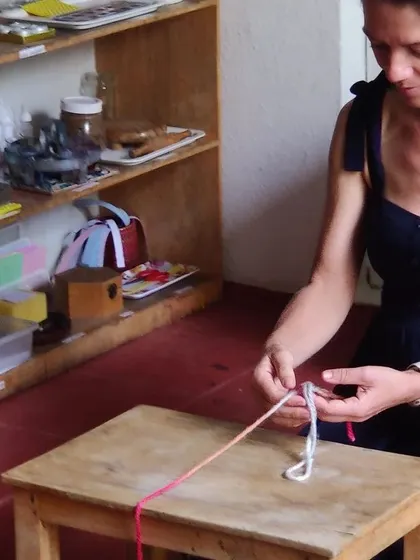 Learning finger knitting, a wonderful activity that builds concentration and coordination. It is a quiet, rhythmic task that can be very calming and satisfying for both children and adults.