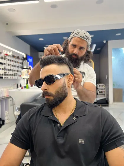 Concentration is key. Here, I'm meticulously crafting a high fade, ensuring every detail is perfect for a sharp and stylish finish.