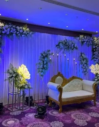 A variation of the blue-lit stage, showing a different arrangement of the floral pieces.