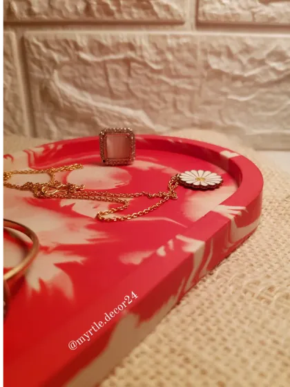 A side view of the red and white marble tray, highlighting its smooth, curved edges.