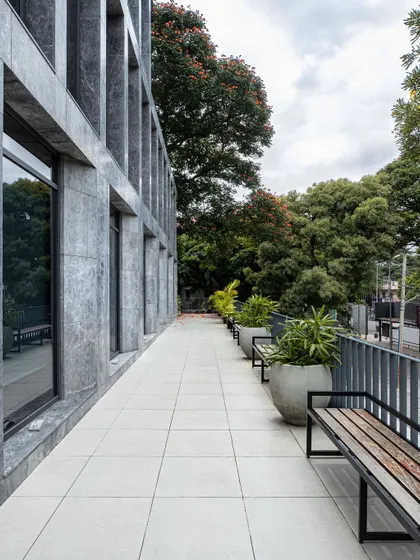 A spacious balcony at The Afyon Pavillion serves as a functional breakout area. Lined with planters and benches, it provides a connection to the outdoors amidst a commercial setting, promoting a healthier work environment.