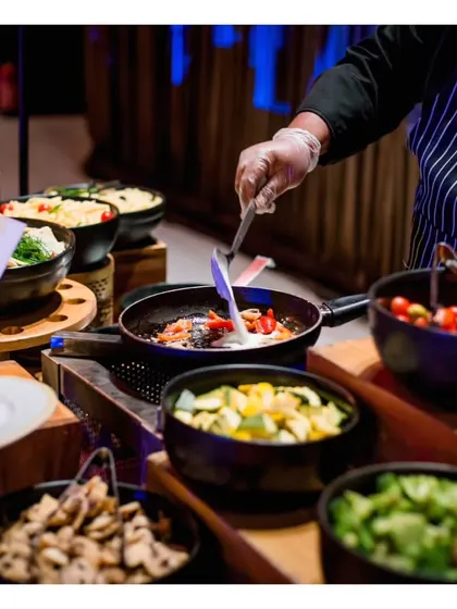 Our live pasta station, where guests can customize their dish with a choice of homemade pastas, sauces, and fresh vegetable toppings, all tossed together by our chef.