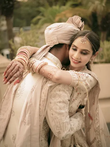 A gentle embrace, showcasing the intricate details of the couple's wedding attire and their loving bond.
