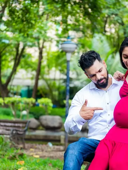 A fun, playful pose with the couple pointing at the baby bump. This lighthearted moment brings out their personalities and adds a dose of humor to their maternity session.
