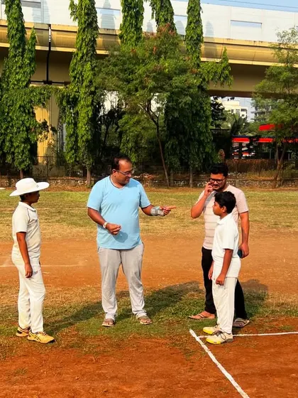 A coach and a parent discuss a player's progress on the field. We believe in a collaborative approach, working closely with families to support our students' development.