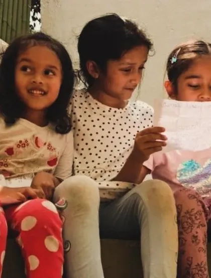 Three friends sit together, sharing and reading poems. In these quiet moments of shared appreciation, a love for language and its expressive power is nurtured.