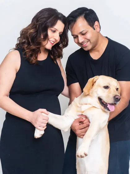 Including a beloved pet in a studio session makes the family portrait complete. This shot is full of warmth and happiness, capturing the bond between the couple and their dog.