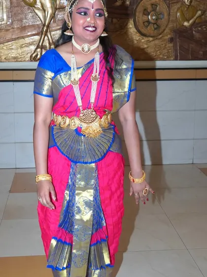 A full-length portrait of a classical dancer in her complete costume and jewelry. This type of shot is essential for documenting the traditional attire of a performance.